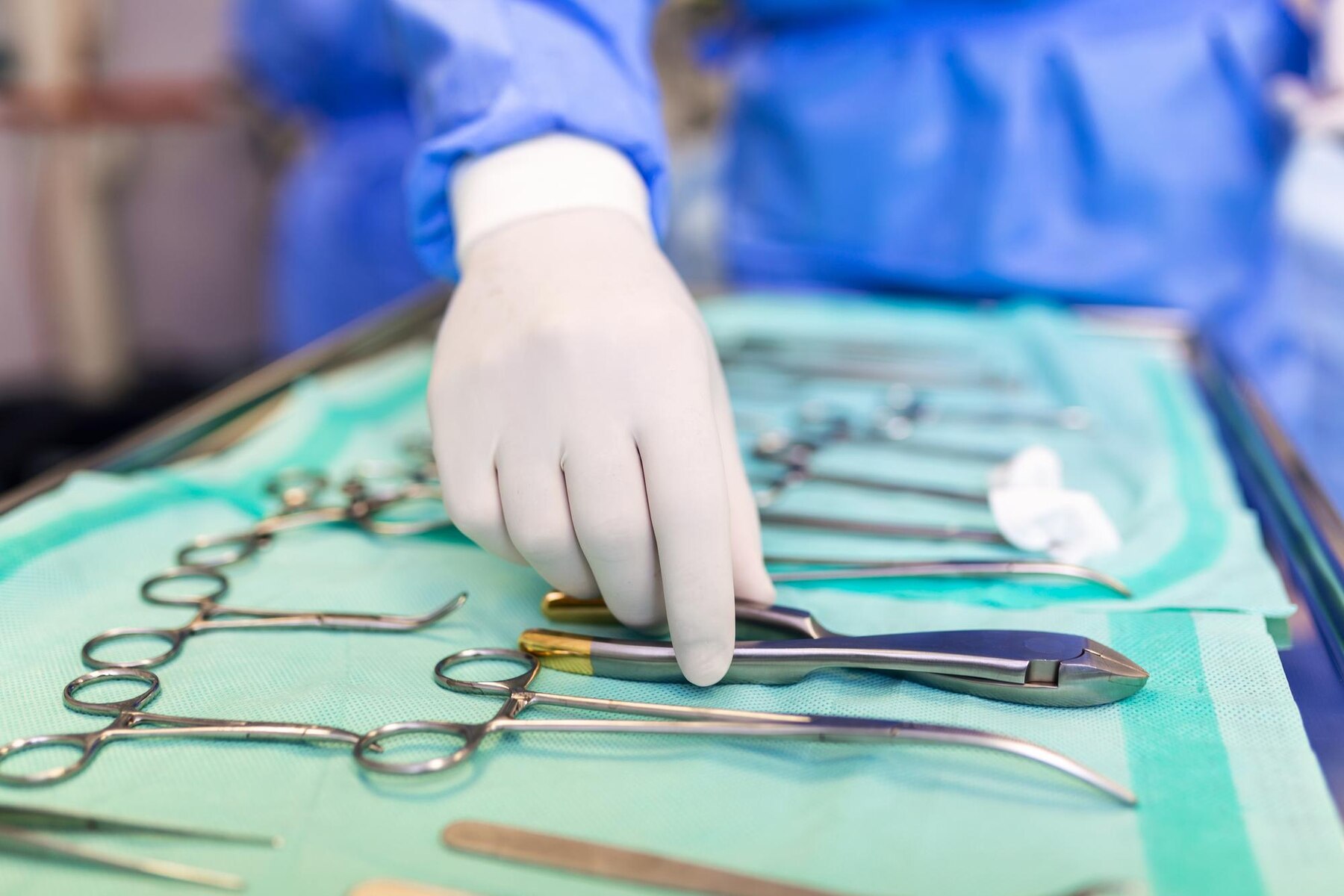 Surgeon picking up surgical tool